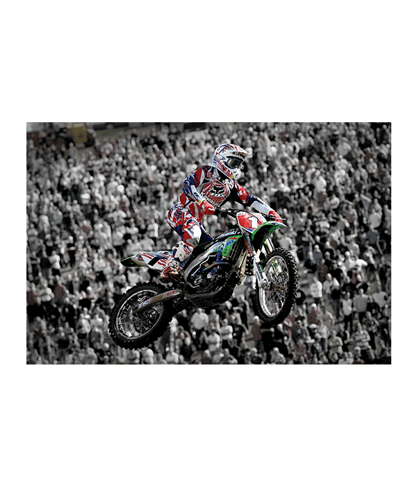 James Stewart jumping dirt bike style at the World FIM Supercross Championship in front of the crowd.